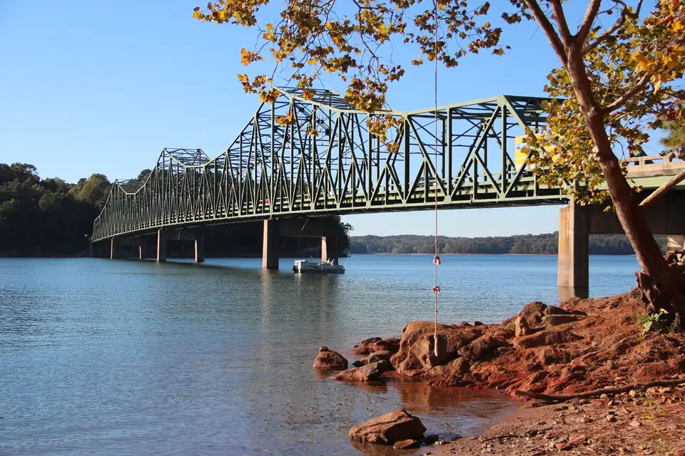 Green steel-truss Browns Bridge carrying SR 369 over Lake Lanier on a clear autumn afternoon