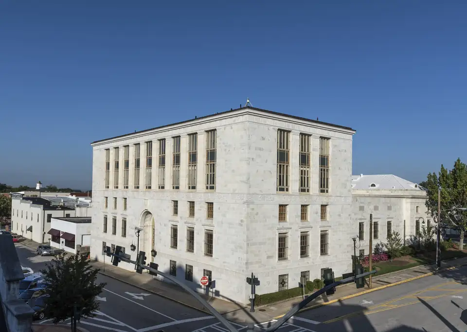 White marble Federal Building and U.S. Courthouse on a downtown Gainesville corner under a deep blue sky