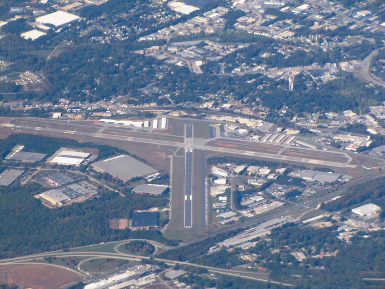 Aerial view of Lee Gilmer Memorial Airport in Gainesville, its crossing runways ringed by large warehouse and light-industrial buildings