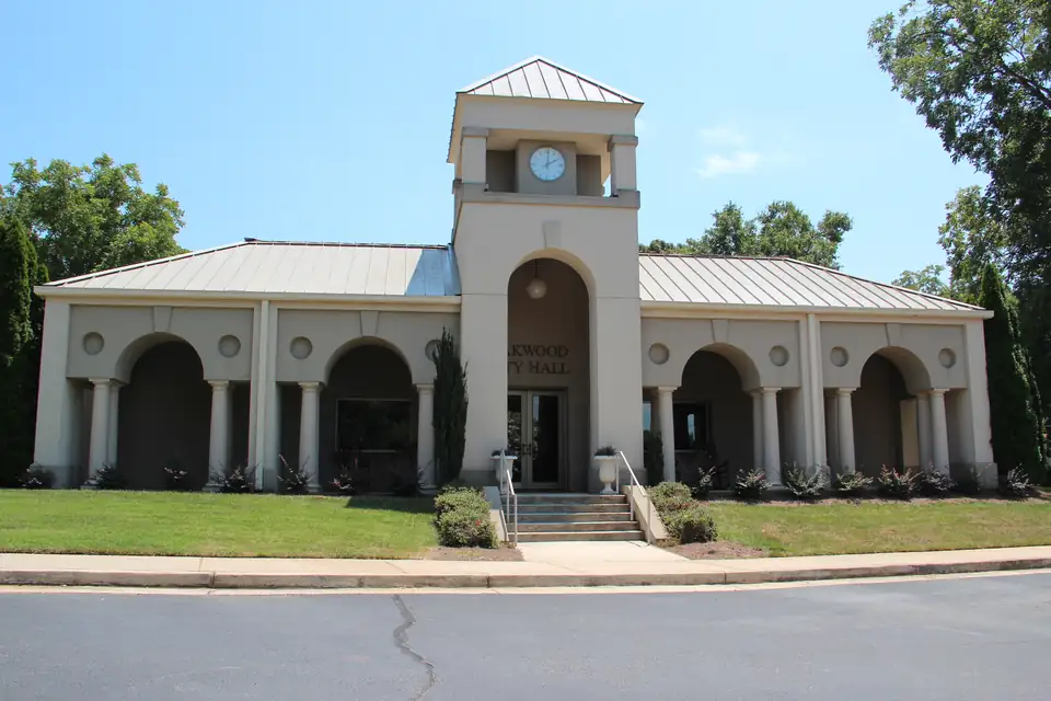 Oakwood City Hall, a cream-colored building with arched windows and a clock tower